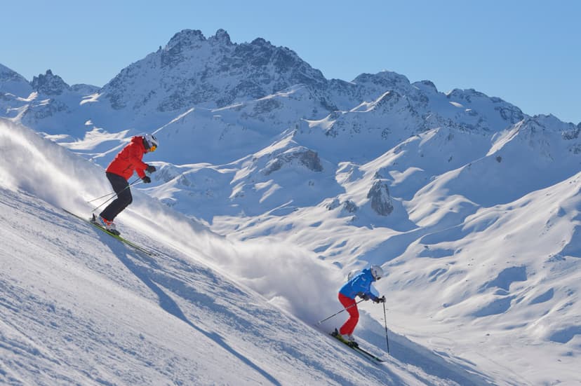 2 skiiers skiing down mountainside in Austria