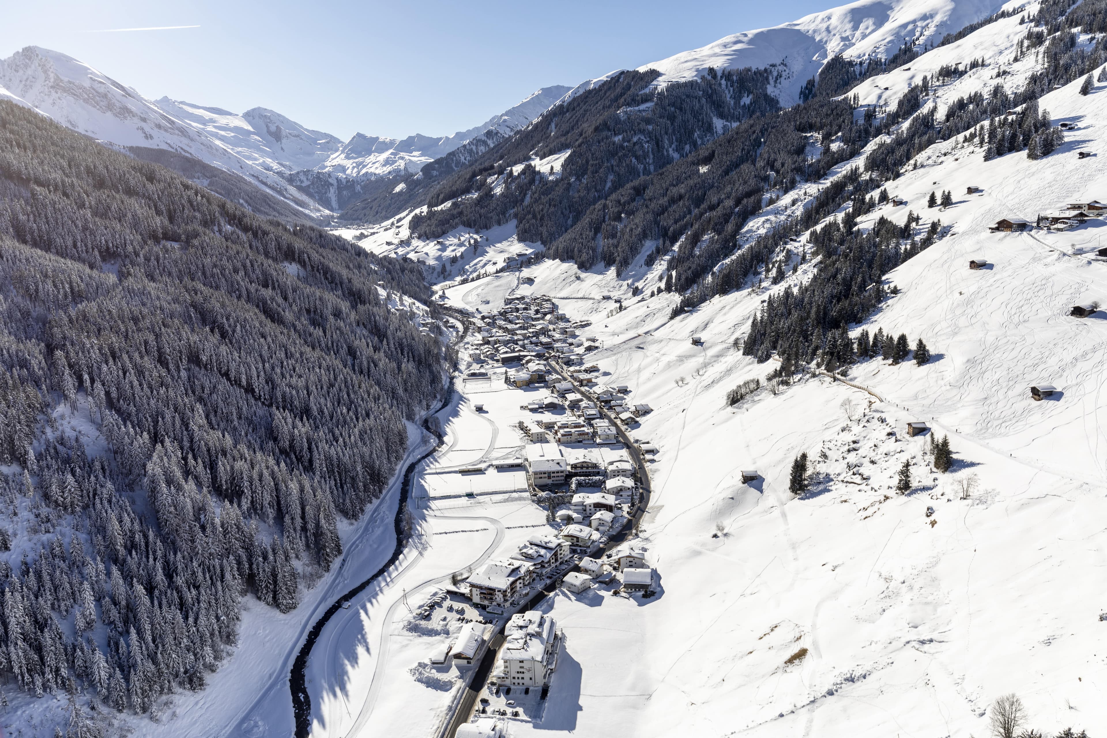 a snow covered valley with trees and a mountain range in the background at Tux ski resort in Austria